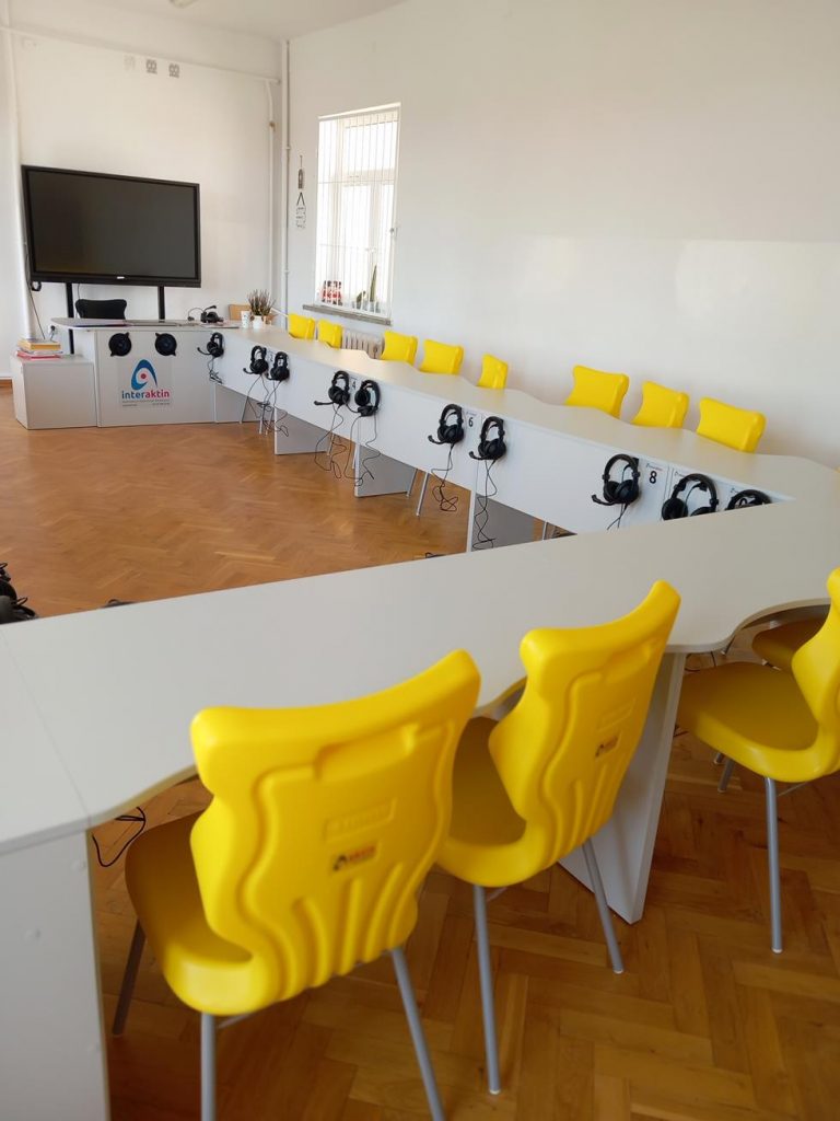 zdjęcie przedstawia wnętrze sali lekcyjnej w PSP Cerekiew. Widać białe ławki oraz żółte krzesła.