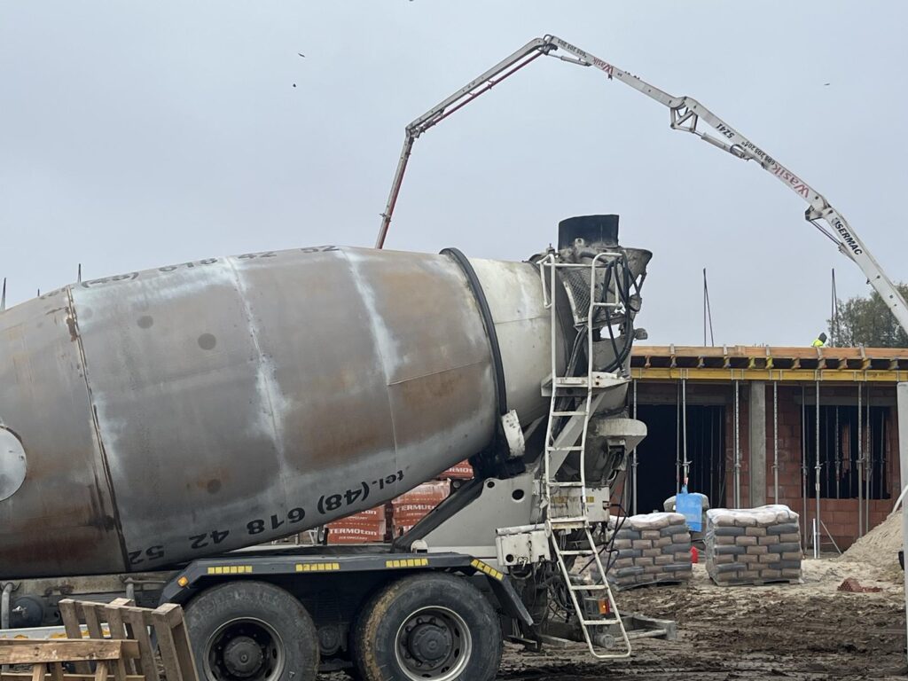 Na zdjęciu zalewanie stropu na żłobku w Zakrzewie, na pierwszym planie betoniarka