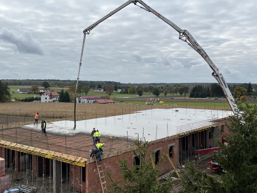 Na zdjęciu zalewanie stropu na żłobku w Zakrzewie w tle zabudowania