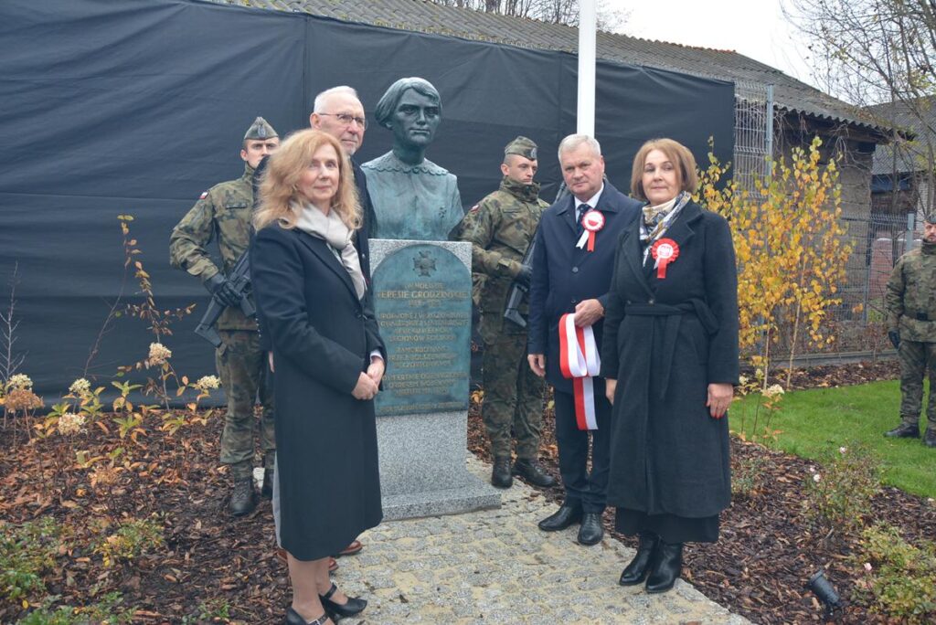 Moment odsłonięcia pomnika Teresy Grodzińskiej. Po bokach pomnika stają po dwie osoby - kobiety i z tyłu mężczyźni.