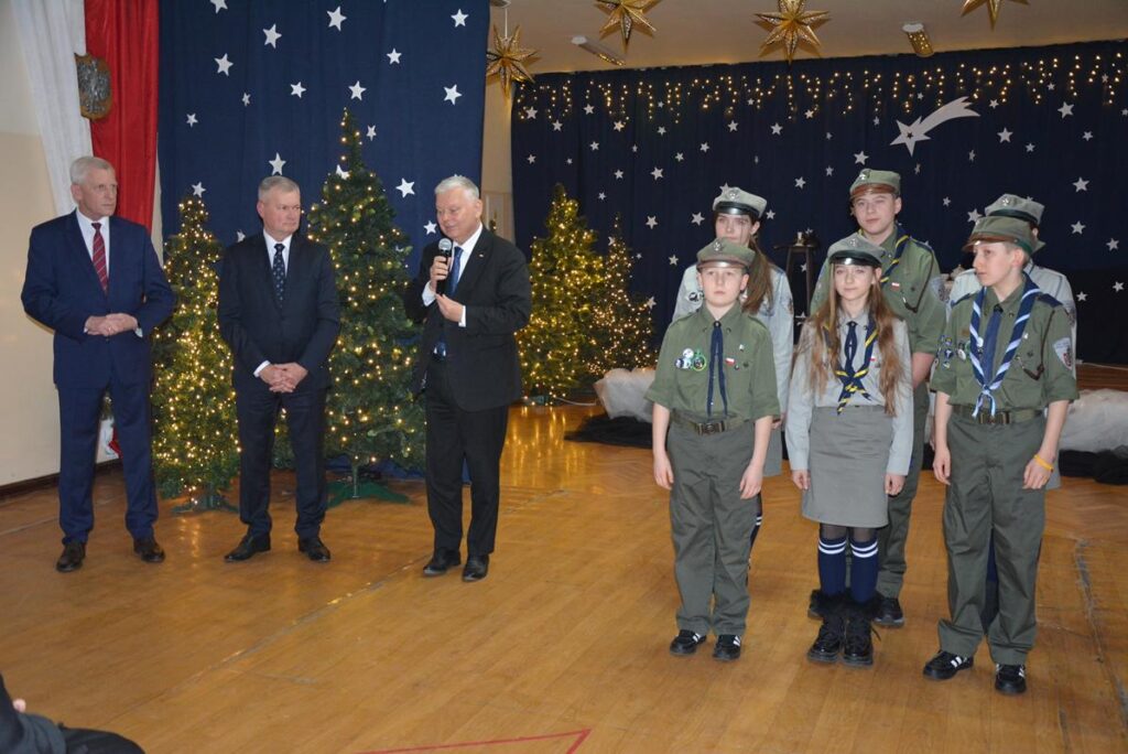 Na zdjęciu widać po lewo przedstawicieli władz a po prawo harcerzy podczas wieczoru wigilijnego odbywającego się w holu PSP w Zakrzewie. 